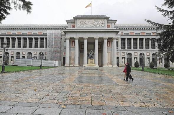 Dos personas pasan ante el Museo del Prado, en Madrid, España.
