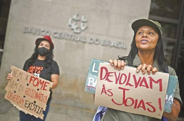 Una mujer sostiene un cartel donde dice “devuélvenos las joyas”, durante una protesta por la reducción de la tasa de interés básica.