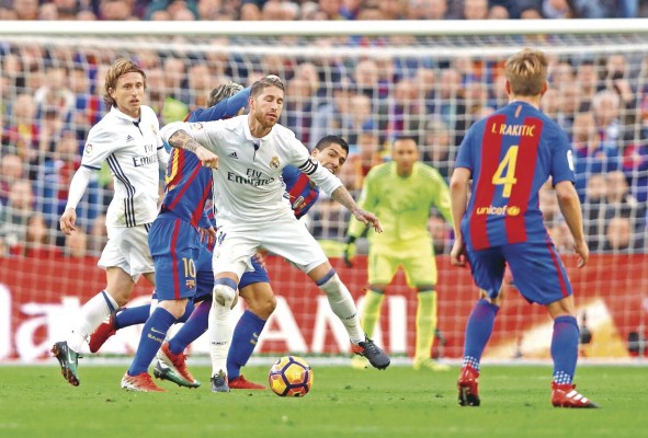 El defensa del Real Madrid Sergio Ramos (c) ante el delantero del FC Barcelona, el argentino Lionel Andrés Messi en el Camp Nou de Barcelona