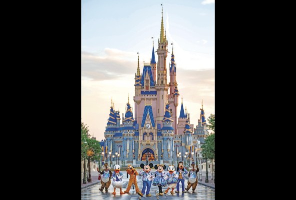 Fotografía cedida por Disney donde aparecen los personajes Mickey Mouse, Minnie Mouse, Pato Donald, Daisy, Goofy, Pluto y Chip 'n' Dale frente al Castillo de Cenicienta.