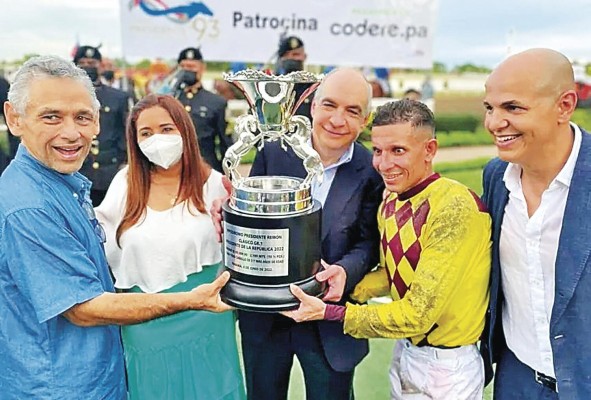 El propietario Isaac Tawachi, Germán Castillo (i) y Luis Arango sostienen la Copa del triunfo, junto a Carlos De Oliveira (d)