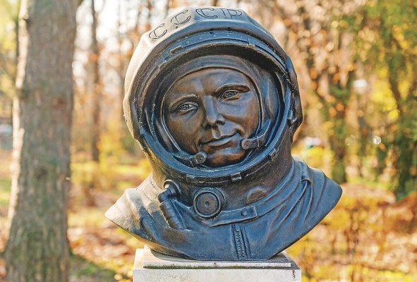 Busto de Yuri Gagarin en un parque en Bucarest, Rumania. Árboles amarillos en el fondo.