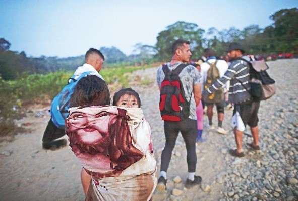 Adultos y niños migrantes hacen fila en la comunidad de Bajo Chiquito, Metetí, Panamá.