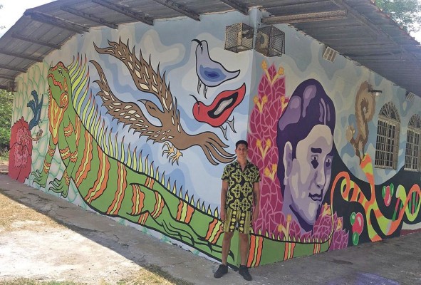 Andrés Villarreal posa frente al mural, todavía en proceso.