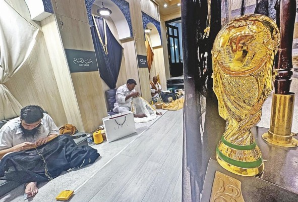Los sastres trabajan con las tradicionales capas árabes negras y doradas (Bisht) en el Zoco Waqif de Doha.