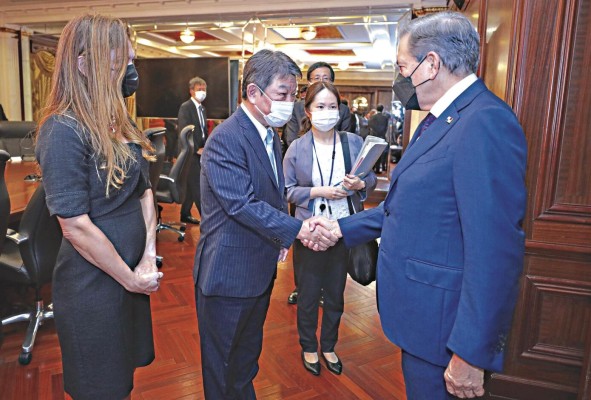 El ministro de Asuntos Exteriores de Japón, Toshimitsu Motegi (i), quien estrecha la mano del presidente de Panamá, Laurentino Cortizo.