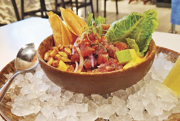 'Ceviche thai', cubos de salmón marinado en mermelada de rocoto, leche de coco y leche de tigre, acompañado de aguacate, mango, cebolla morada, coronado con coco crocante.