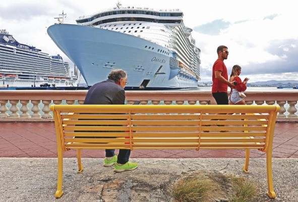 Personas caminan frente a un crucero en el puerto de San Juan, en una fotografía de archivo.