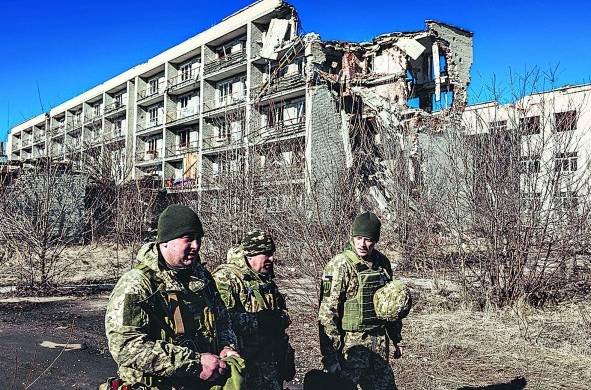 Varios soldados ucranianos caminan frente a un edificio derruido en Marinka, Oblast de Donetsk (Ucrania)