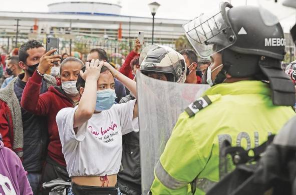La policía requisa a un manifestante de la llamada 'primera línea', que son quienes enfrentan a la policía durante los disturbios.