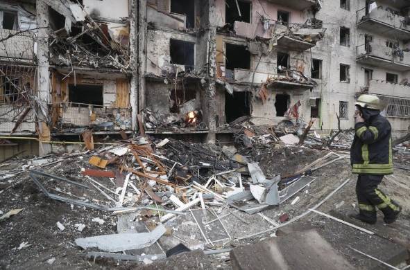 Un miembro de los servicios de emergencia evalúa los daños ocasionados por los bombardeos rusos sobre una zona residencial de Kiev.
