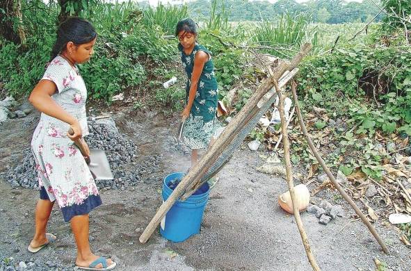Dos niñas trabajan limpiando piedrín en la ciudad de Guatemala.