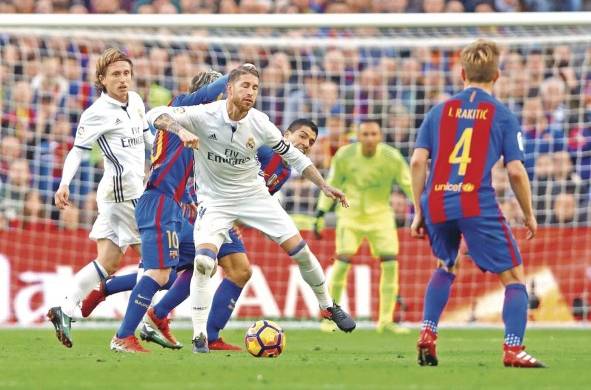 El defensa del Real Madrid Sergio Ramos (c) ante el delantero del FC Barcelona, el argentino Lionel Andrés Messi en el Camp Nou de Barcelona