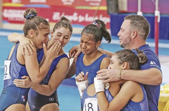 El equipo femenino panameño se abraza con su entrenador, tras obtener la medalla de bronce en la competencia general.