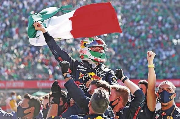 Integrantes de la escudería de Red Bull celebrando el podio conseguido de Sergio Pérez.
