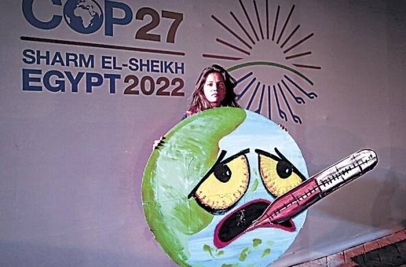 Un activista sostiene un cartel en la Conferencia de las Naciones Unidas sobre el Cambio Climático (COP27) de 2022.