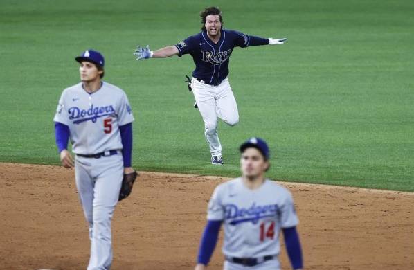 Brett Phillips (c), guardabosque de los Rays de Tampa Bay, fue registrado este sábado al festejar la victoria de su equipo 8-7 sobre los Dodgers de Los Ángeles