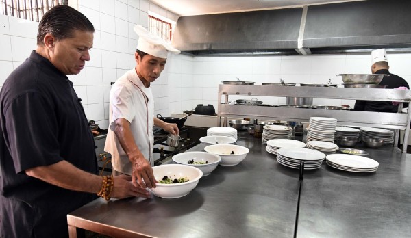 El maestro observa los platillos en la cocina del restaurante Tien Tan, en La Habana.