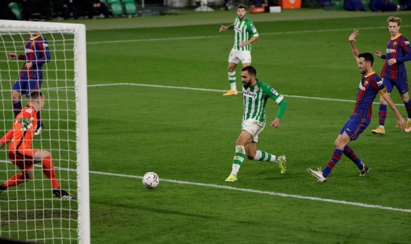 El delantero del Real Betis Balompié Borja Iglesias (c) remata para marcar el 1-0 ante Marc-André Ter Stegen (i) y Sergio Busquets (d), ambos del FC Barcelona