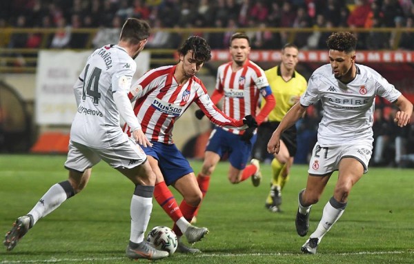 El atacante portugués del Atlético de Madrid, Joao Felix (c), intenta llevarse el balón. 