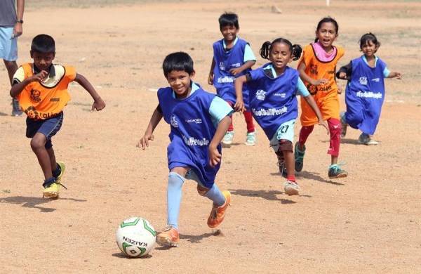 Niñas y niños juegan al fútbol en la Academia de Deportes de Anantapur, en la India. |