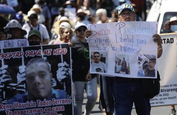 Una mujer muestra un cartel con fotografías de una joven y el pedido de su libertad, durante una marcha de familiares de detenidos
