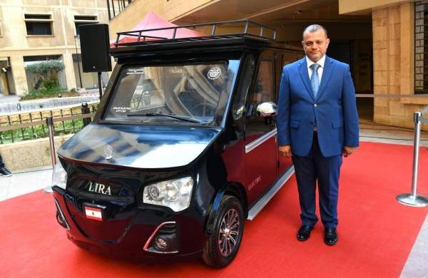 El libanés Hisham Houssami posa junto a su prototipo del Lira, un nuevo coche híbrido que funciona con una mezcla de electricidad y energía solar.