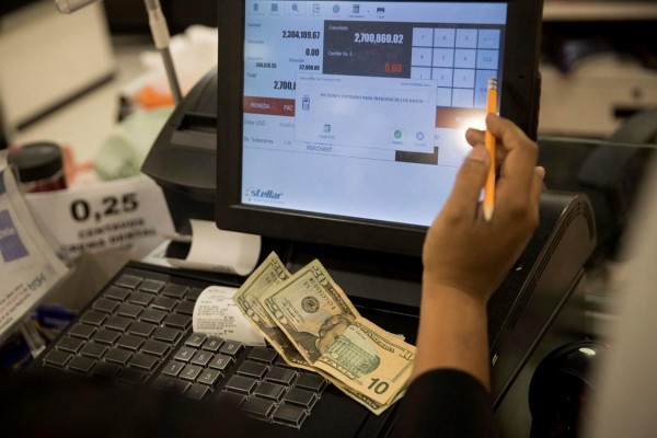 Vista de una caja registradora con dólares en una tienda de Caracas, en una fotografía de archivo.