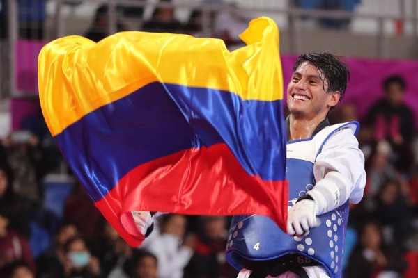 Fotografía de archivo en la que se registró al taekwondista colombiano Miguel Ángel Trejos, al ondear una bandera de su país durante los Juegos Panamericanos 2019, en Lima (Perú).