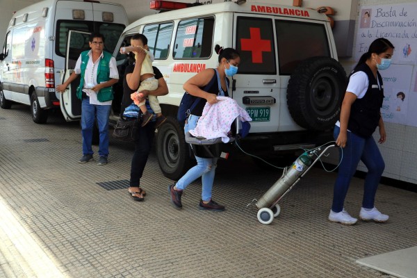 Padres de familia ingresan a su hijo hoy a un hospital en Bolivia, en una fotografía de archivo.