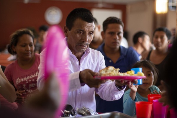 En esta foto del 25 de julio del 2019, un migrante guatemalteco recibe un plato de comida en el albergue El Buen Pastor en Ciudad Juárez, México.
