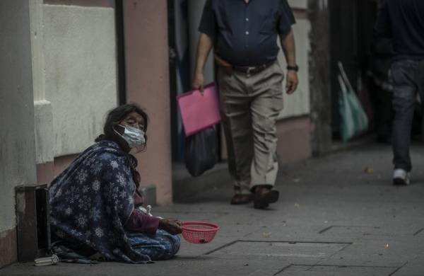 Una mujer pide dinero en la Sexta Avenida el 12 de julio 2022, en Ciudad de Guatemala