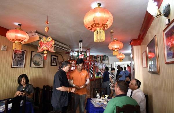 El maestro en artes marciales chinas junto a comensales en el restaurante Tien Tan, en La Habana.