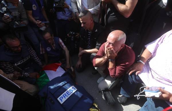 Periodistas palestinos lloran cerca del cuerpo de la periodista de Al Yazira Shireen Abu Akleh en la ciudad cisjordana de Jenin.
