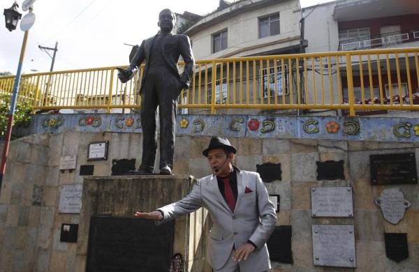 El artista Oscar Manuel Zuluaga, del teatro Arlequin y los juglares, canta frente a una estatua del legendario Carlos Gardel.
