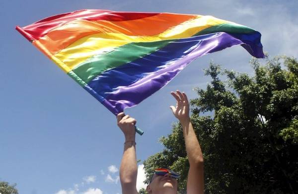 Un hombre agita una bandera LGBTI durante la marcha del orgullo gay en Medellín (Colombia).