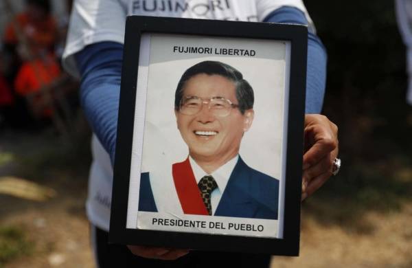 Fotografía de archivo en la que se registró a un seguidor del expresidente peruano Alberto Fujimori al sostener en sus manos una foto del exmandatario, en Lima (Perú). EFE/Paolo Aguilar