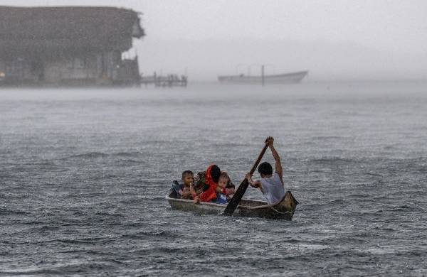 Un indígena Guna con su familia rema en una canoa en la isla de Carti Sugtupu, en la Comarca Indígena Guna Yala, Panamá, en el Mar Caribe.