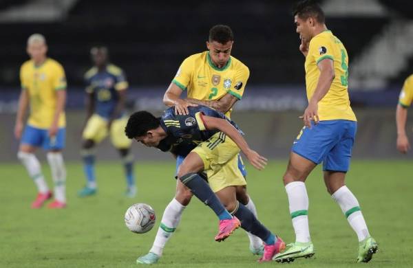 Danilo (i) y Casemiro (d) de Brasil disputan el balón con Luis Díaz de Colombia