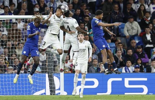 El defensa del Real Madrid Eder Militao (2i) despeja de cabeza junto a Trevoh Chalobah (i), del Chelsea