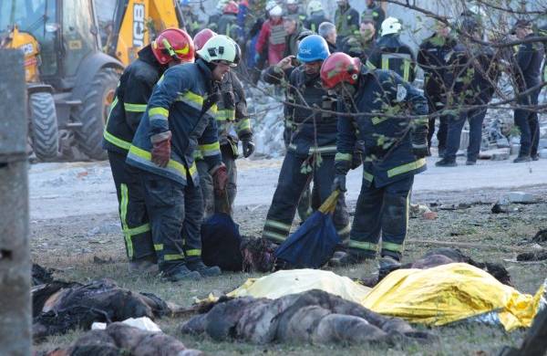 Rescatistas trabajan cerca de cadáveres en el lugar del ataque con misiles en la región oriental ucraniana de Járkov, con más de medio centenar de civiles muertos.