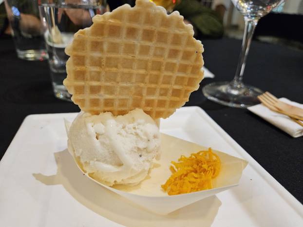 Helado de yogur, infusión de té Earl grey con decoración de cono redondo y ralladura de naranja.