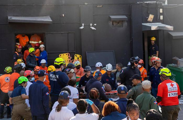 Integrantes del cuerpo de bomberos y de rescate evacúan a un herido este martes, en la discoteca Jet Set en Santo Domingo (República Dominicana). EFE/ Orlando Barría