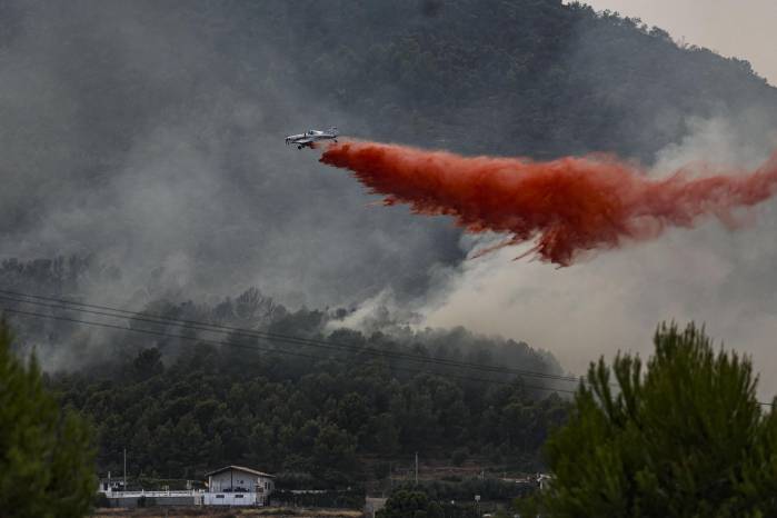 Un avión realiza una descarga con retardante en Betxí en el frente del incendio declarado este sábado en la Vall d'Uixó (Castellón), y que lleva quemadas ya unas 4.300 hectáreas y cuyo perímetro supera los 40 kilómetros.