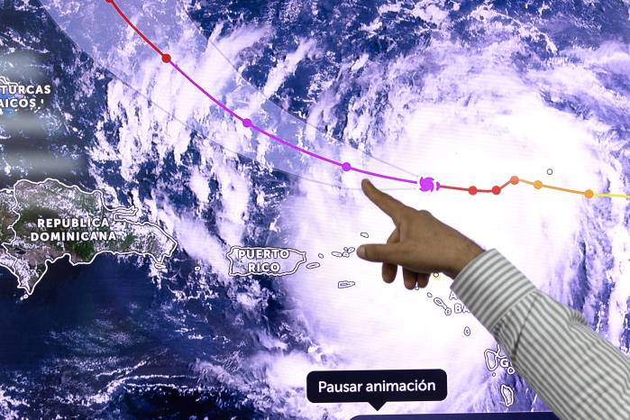 El predictor de la Oficina Nacional de Meteorología, Wagner Rivera, muestra en pantalla el paso del huracán Erin.