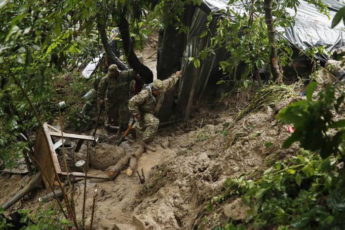 Soldados recorren la zona donde un derrumbe destrozó una vivienda este martes, en Ciudad Delgado (El Salvador).