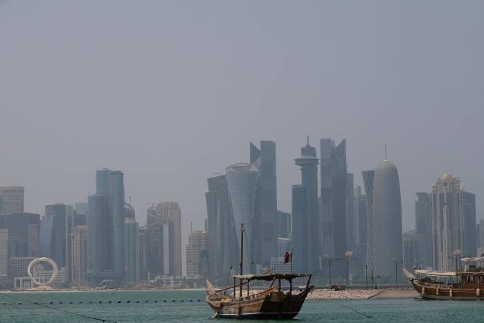 A picture shows a moored dhow with the Doha skyline in the background on a hot and humid summer day on August 6, 2025. (Photo by Karim JAAFAR / AFP)