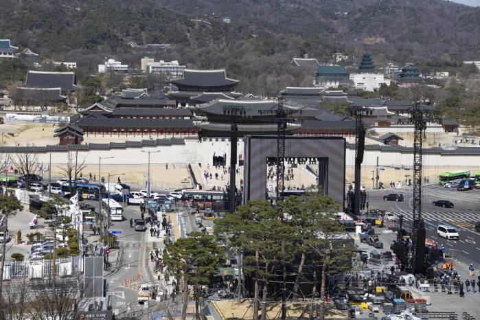 Trabajadores preparan el escenario principal para un concierto gratuito del grupo de K-pop BTS en la plaza Gwanghwamun de Seúl, Corea del Sur