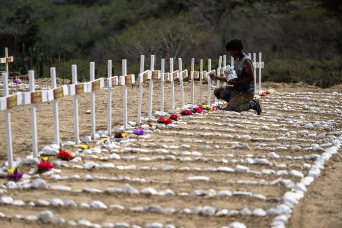 Un trabajador pinta tumbas para víctimas no identificadas del terremoto del 24 de junio en el cementerio La Esperanza, en Catia La Mar, estado La Guaira, al noreste de Caracas, el 5 de julio de 2026.