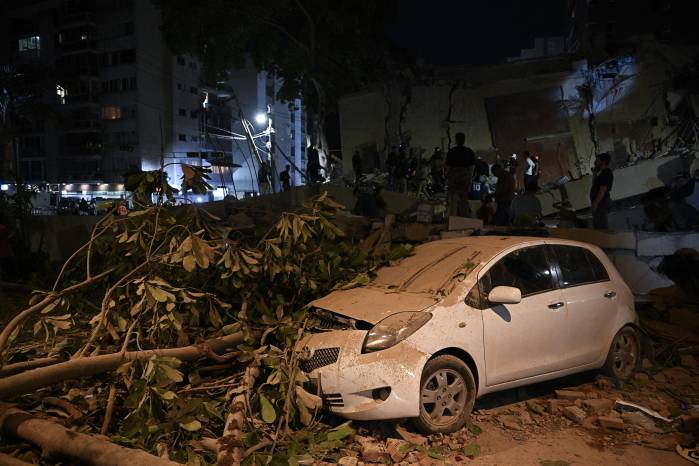 Se ve un automóvil aplastado por un árbol caído después de un terremoto en Caracas.
